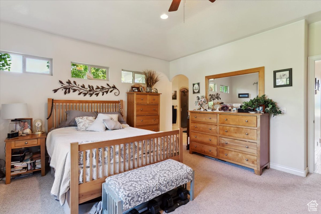 Bedroom featuring arched walkways, multiple windows, ceiling fan, light colored carpet, and recessed lighting