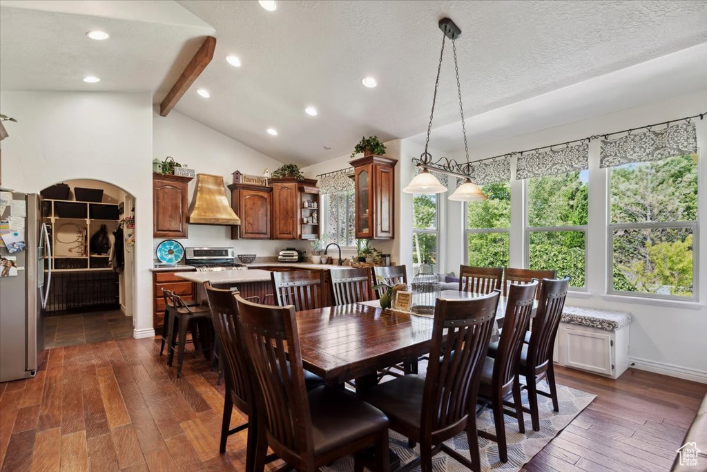 Dining space featuring dark wood finished floors, baseboards, recessed lighting, and arched walkways