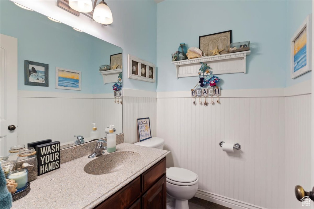 Bathroom with toilet, wainscoting, and vanity