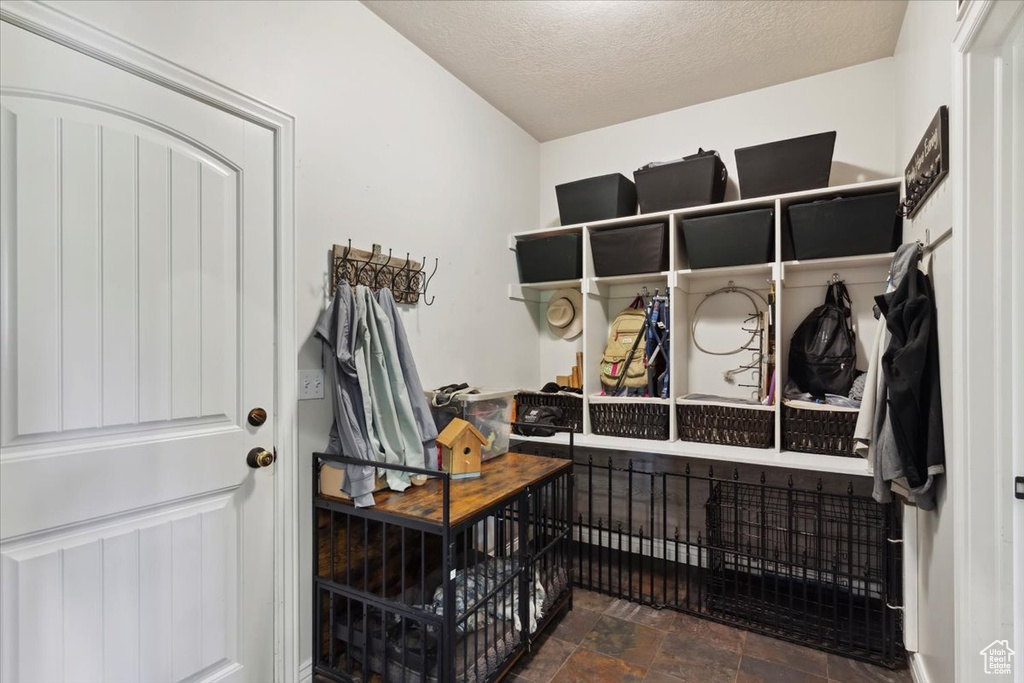 Mudroom featuring a textured ceiling and stone finish floors