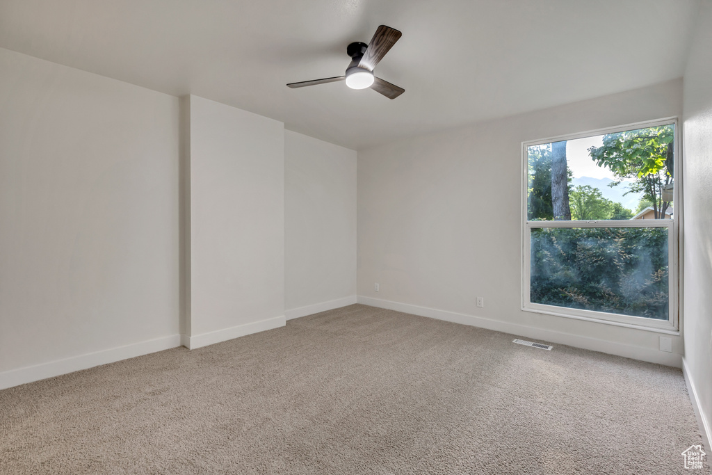 Unfurnished room with a ceiling fan, carpet, and baseboards