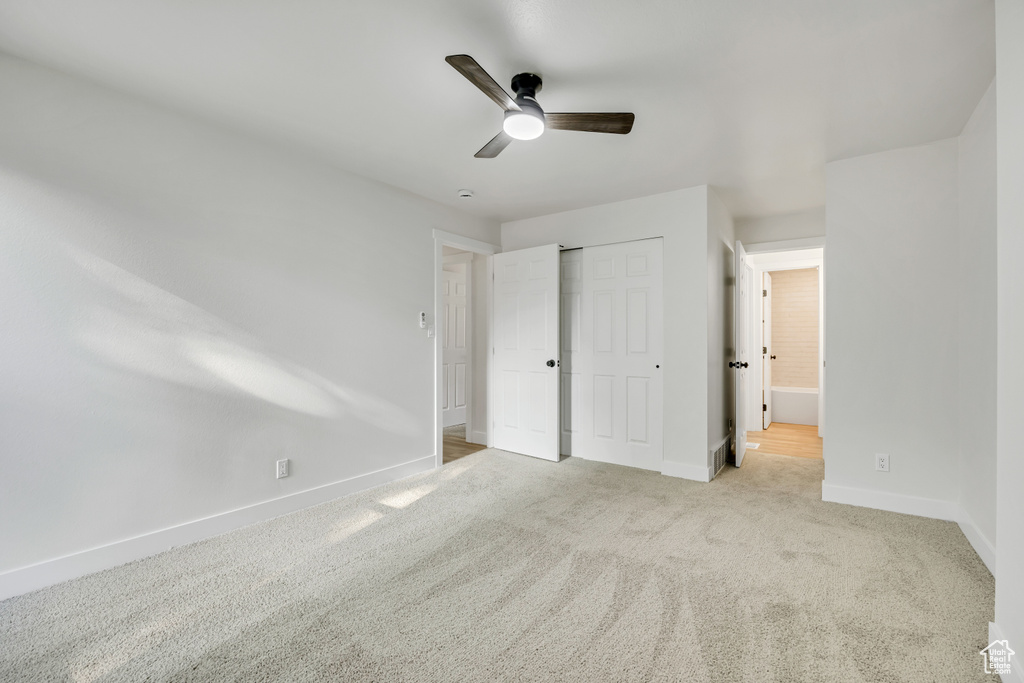 Unfurnished bedroom with baseboards, carpet floors, a closet, and ceiling fan