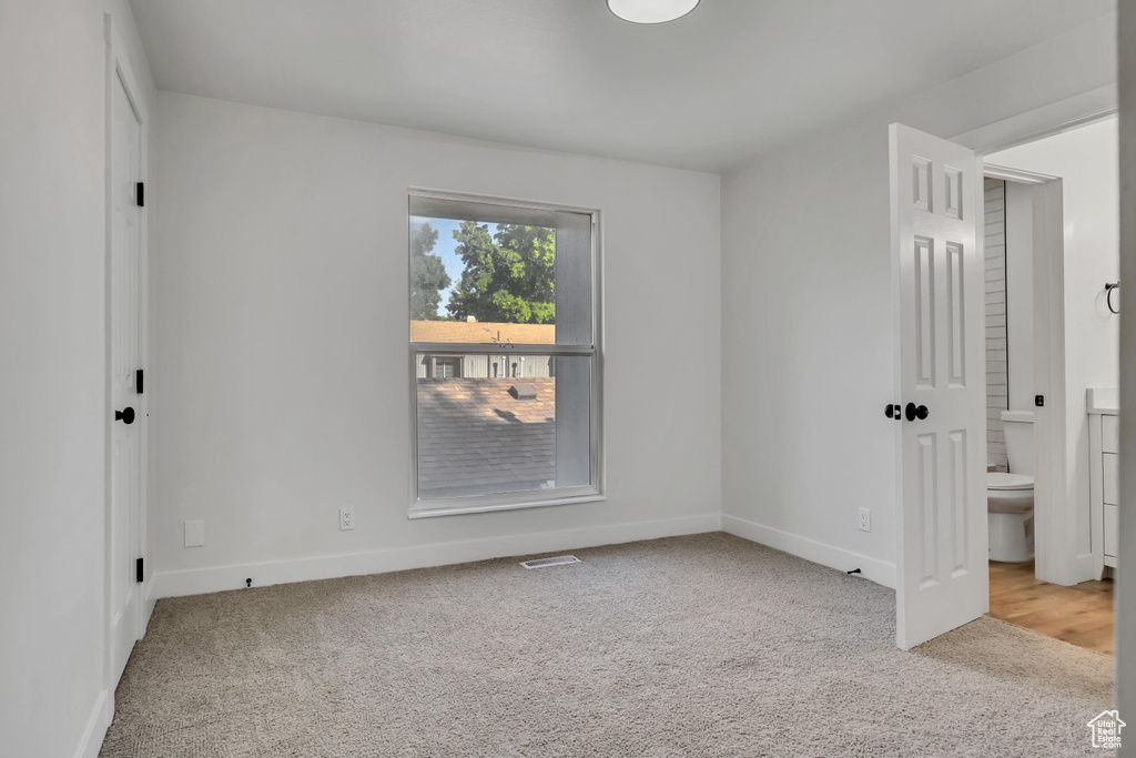Unfurnished bedroom featuring carpet, baseboards, and connected bathroom