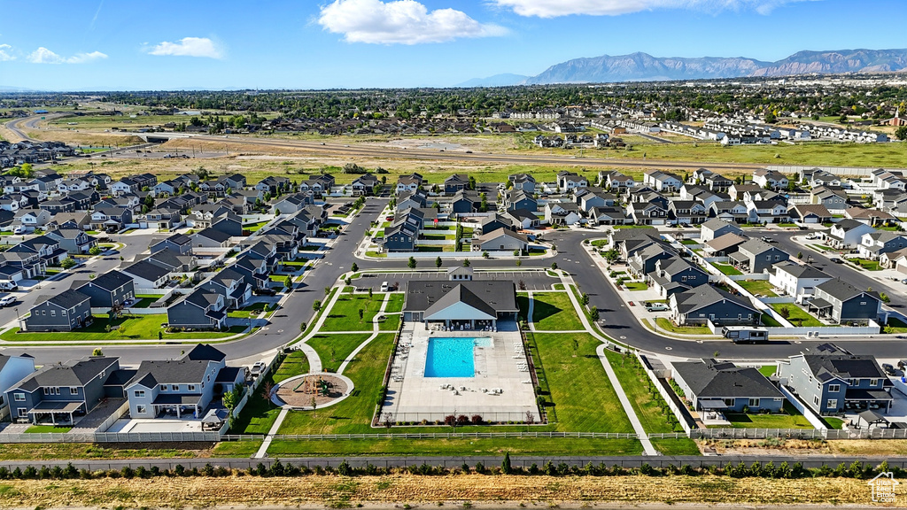 Aerial perspective of suburban area featuring a pool and a mountain backdrop