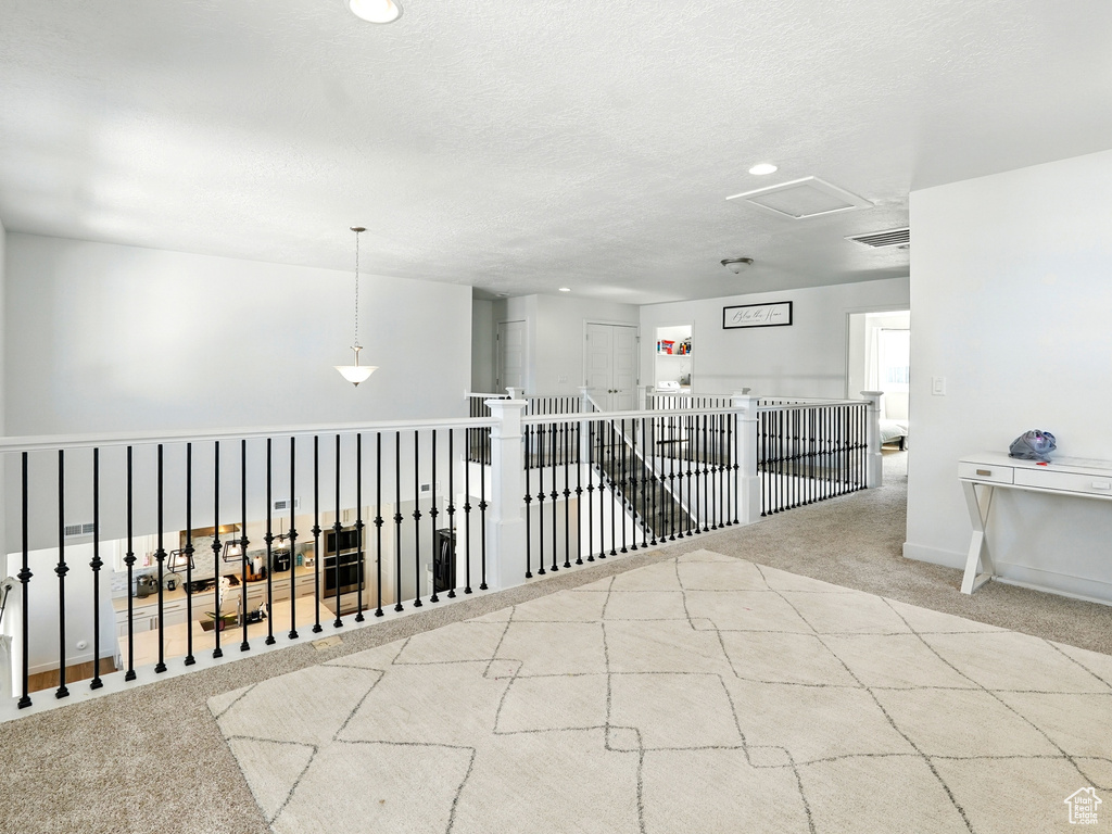 Hallway featuring carpet flooring, recessed lighting, a textured ceiling, and baseboards