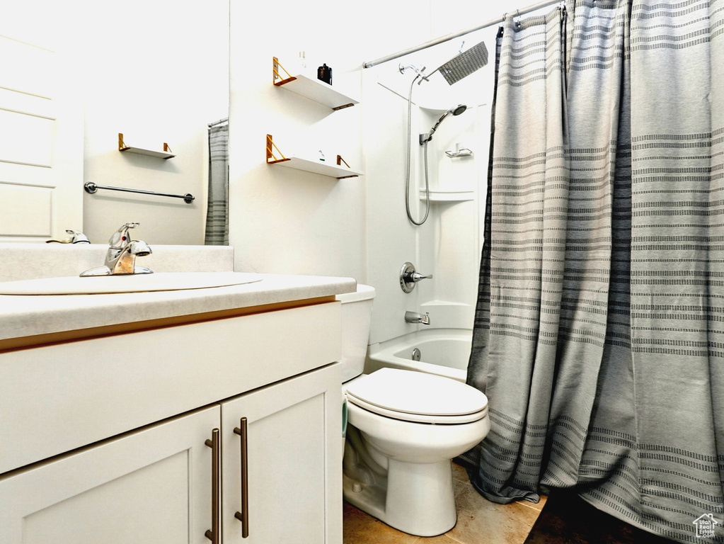 Full bath featuring vanity, shower / bath combo with shower curtain, and toilet