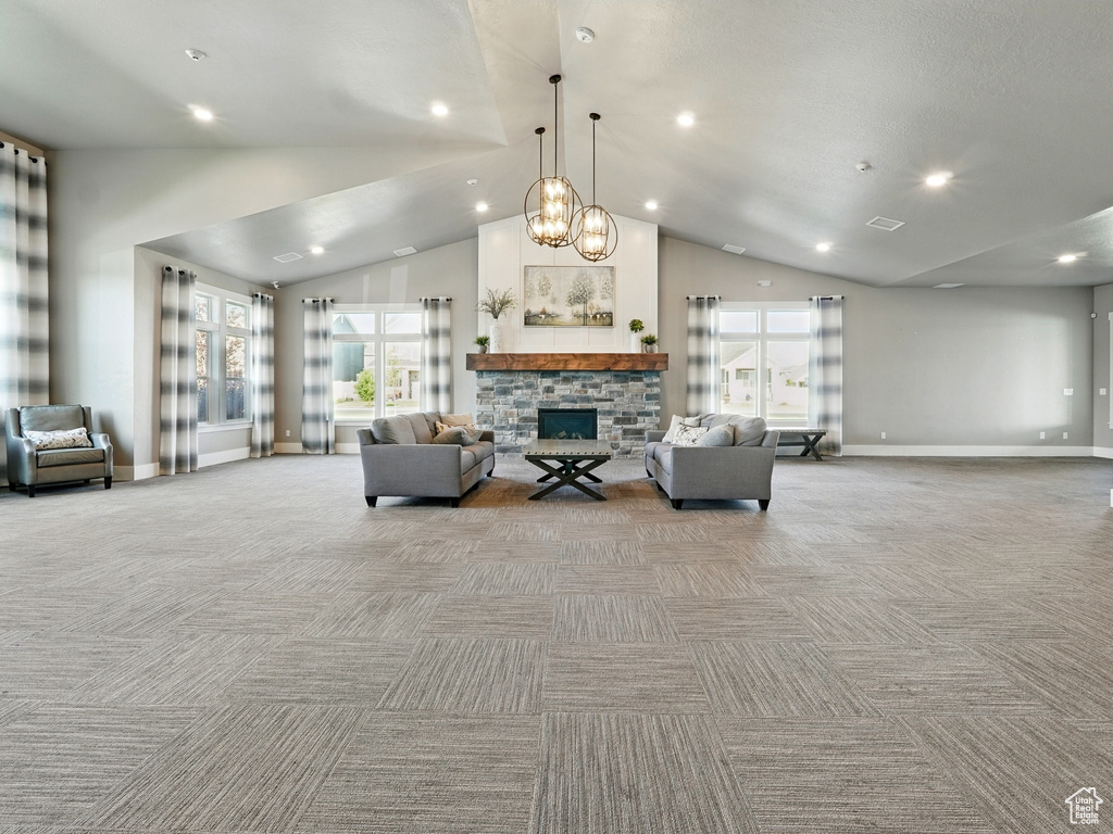 Living area featuring light colored carpet, baseboards, lofted ceiling, recessed lighting, and a fireplace