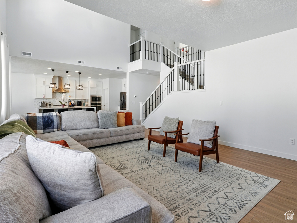 Living room with light wood finished floors, stairway, and baseboards