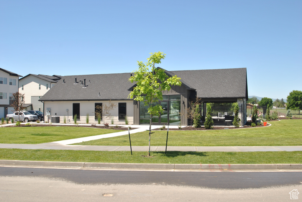 View of front of house featuring a front yard and roof with shingles