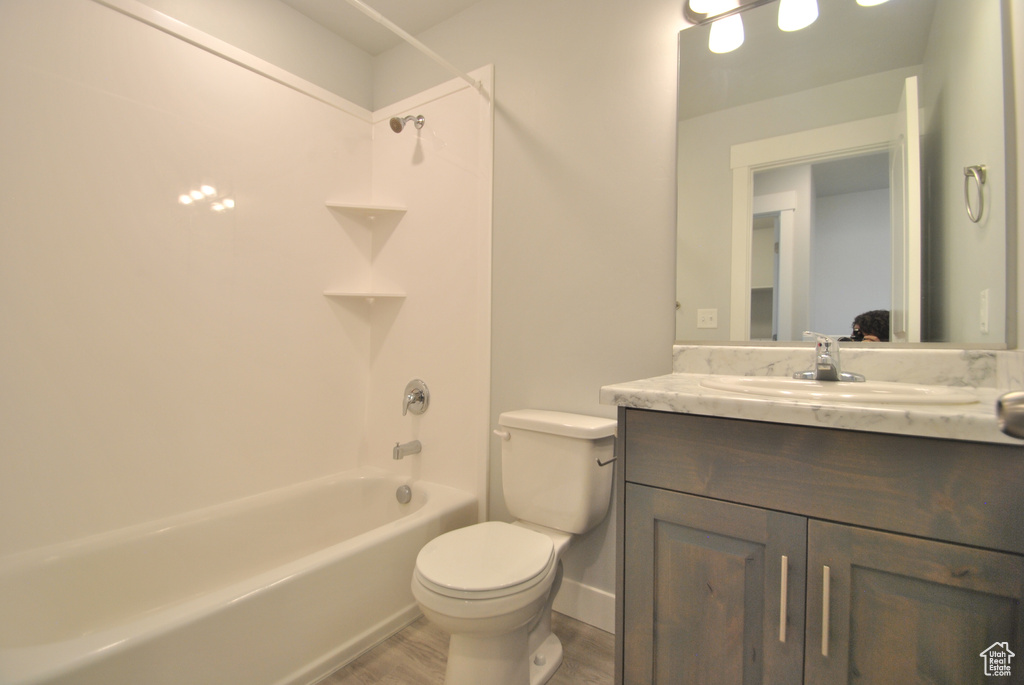 Bathroom featuring vanity,  shower combination, toilet, and wood finished floors