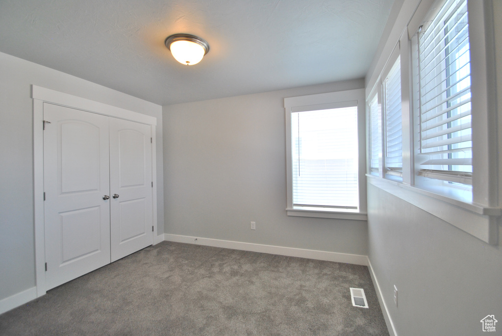 Unfurnished bedroom with carpet flooring, baseboards, and a closet