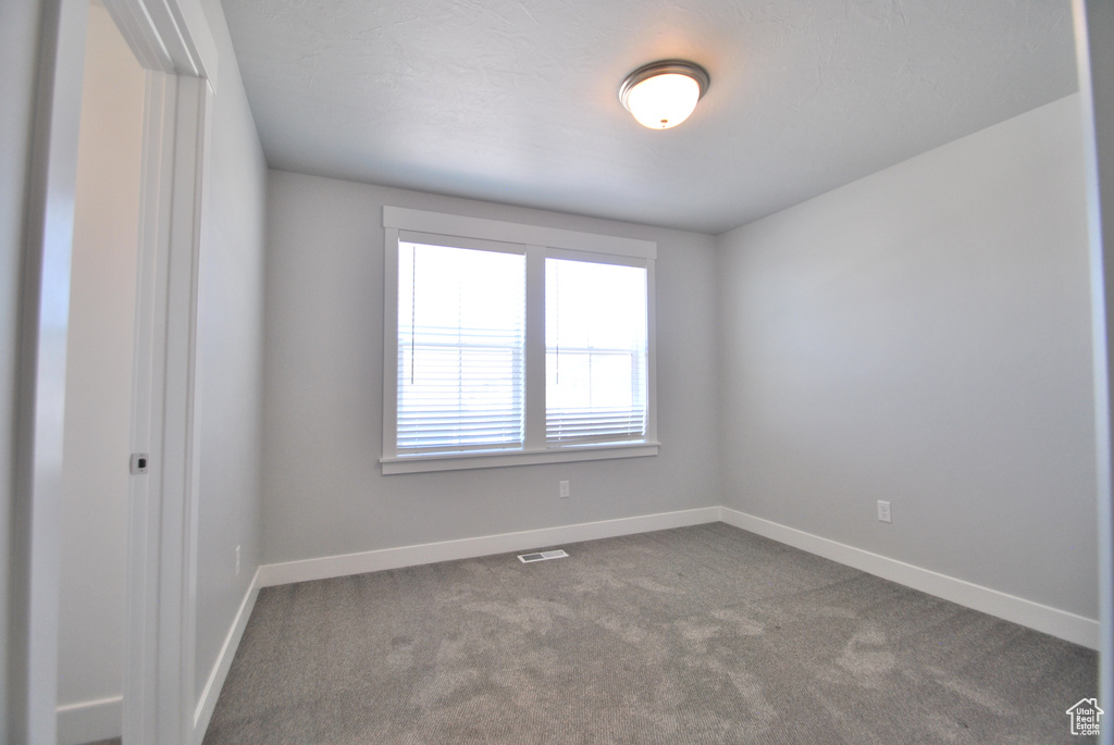 Carpeted spare room with baseboards