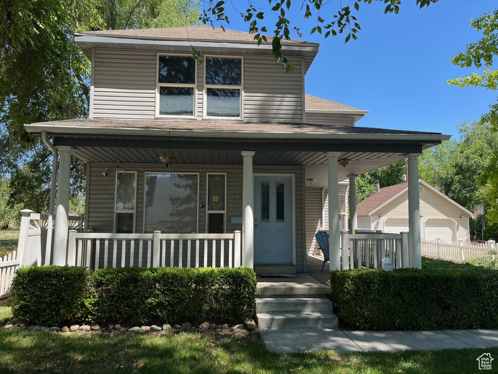 View of front of house featuring covered porch and a shingled roof