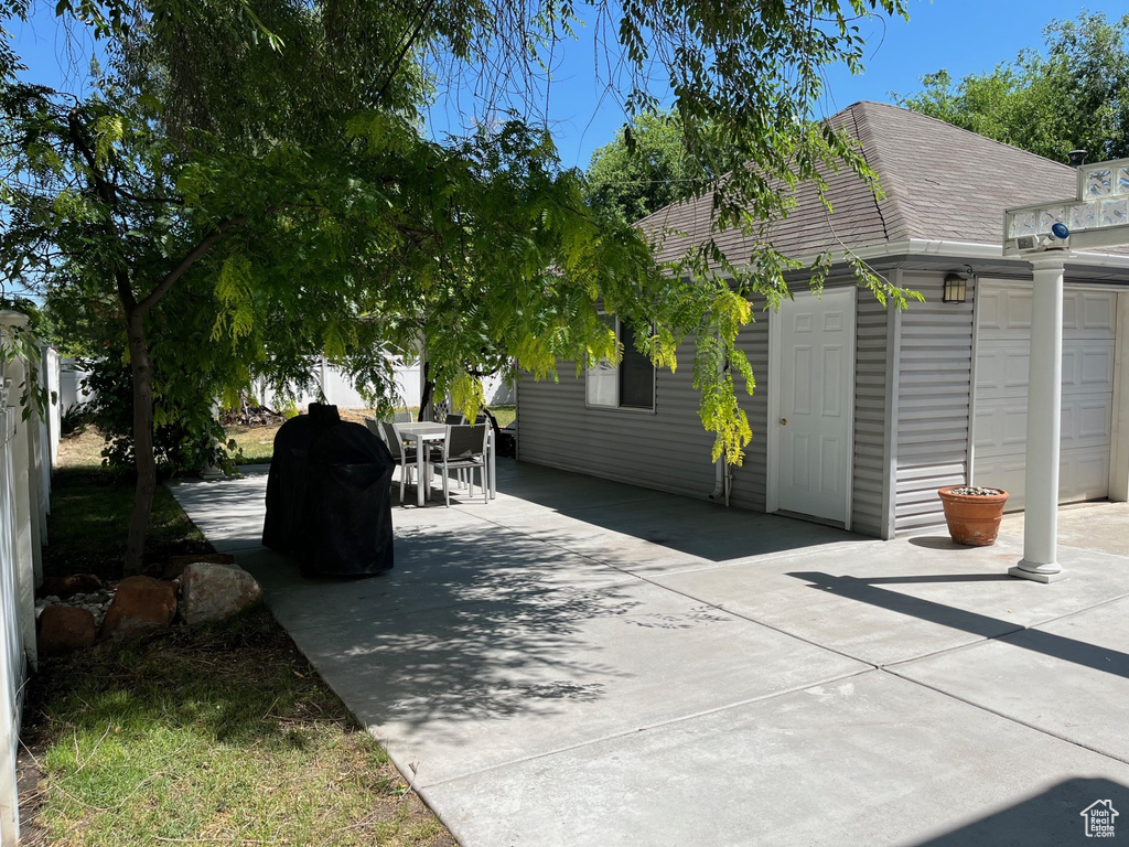 View of patio featuring outdoor dining area and an attached garage