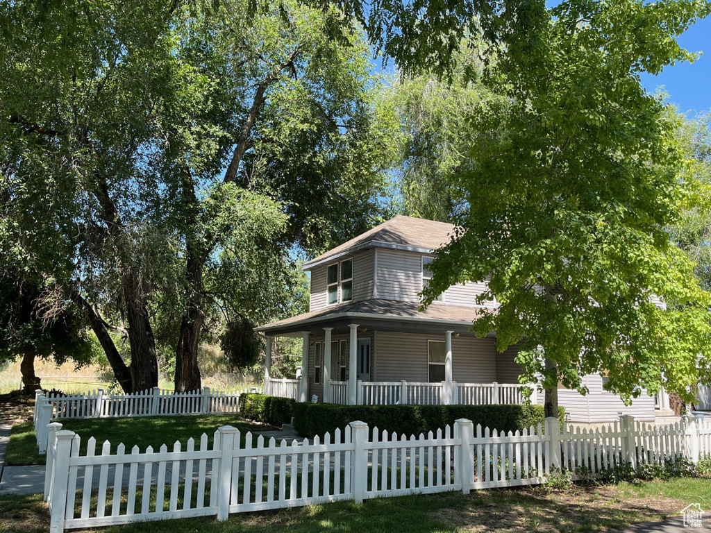 Farmhouse inspired home with a porch and a fenced front yard