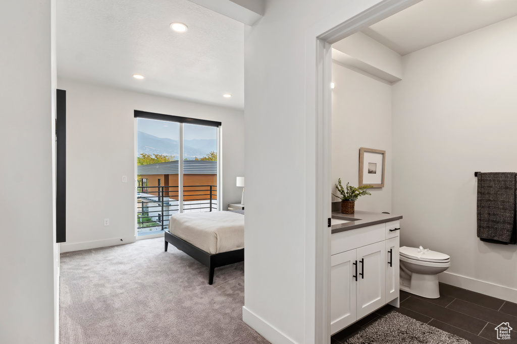 Bathroom featuring vanity, toilet, baseboards, and recessed lighting