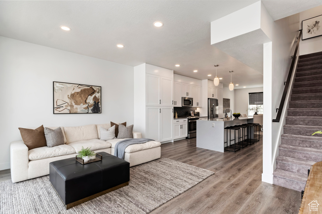 Living area featuring stairway, recessed lighting, and wood finished floors