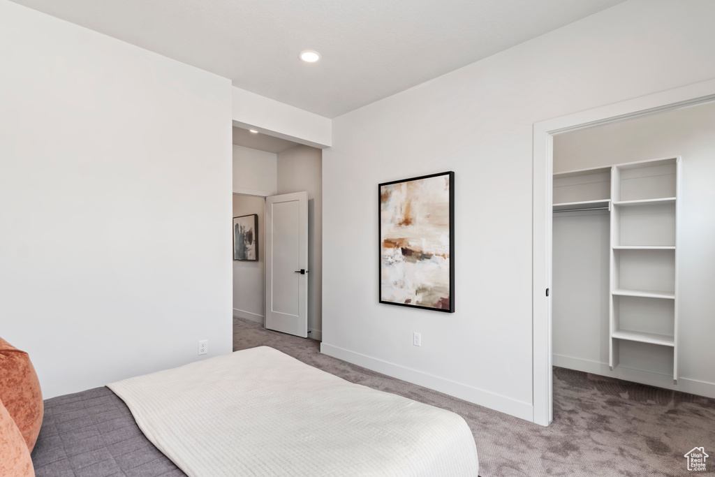 Carpeted bedroom featuring a spacious closet, baseboards, recessed lighting, and a closet