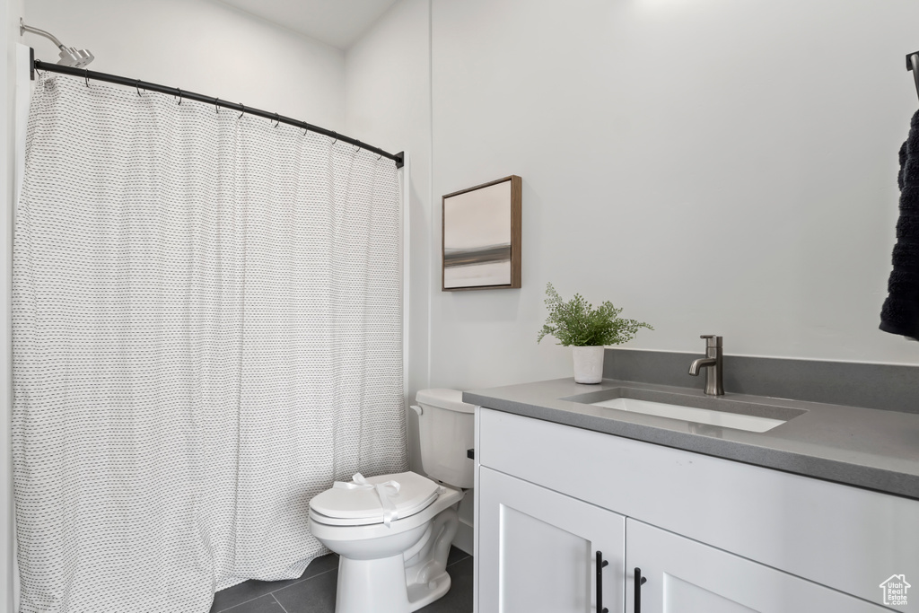Bathroom featuring toilet, tile patterned flooring, vanity, and a shower with shower curtain