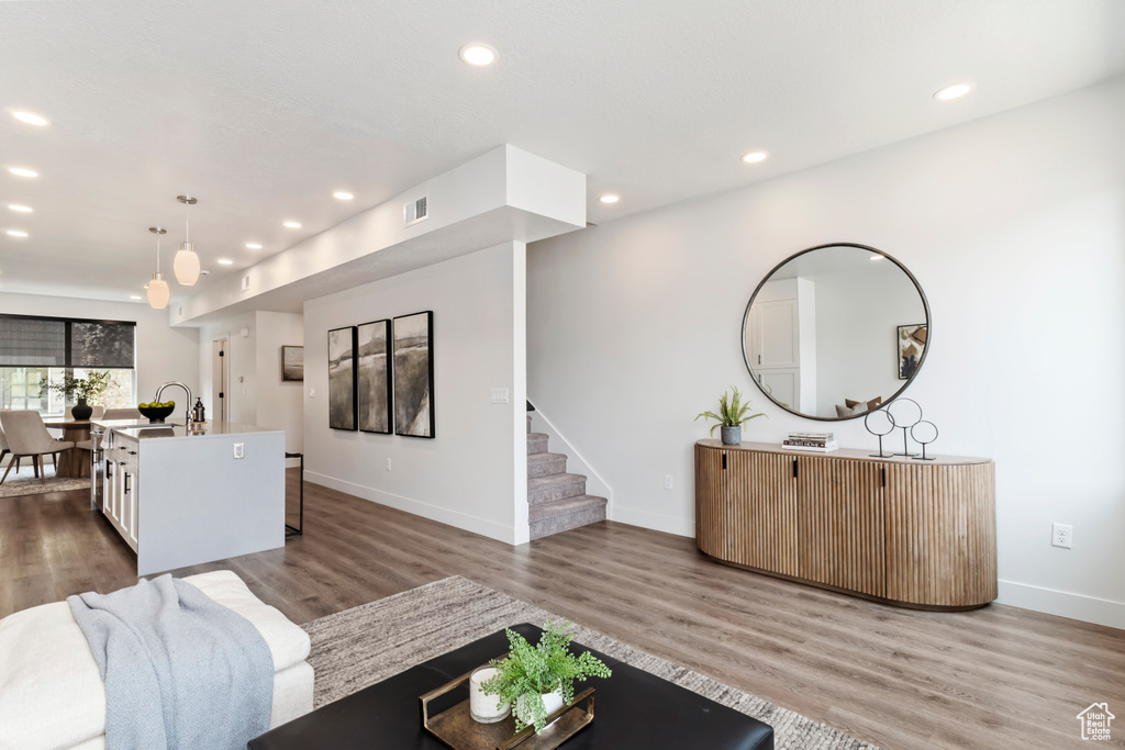 Living room featuring wood finished floors, recessed lighting, baseboards, and stairway