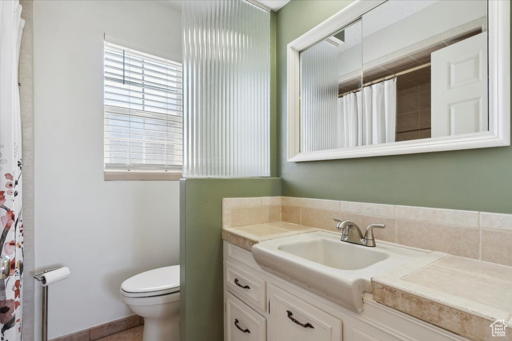 Full bathroom with vanity, toilet, and a shower with curtain