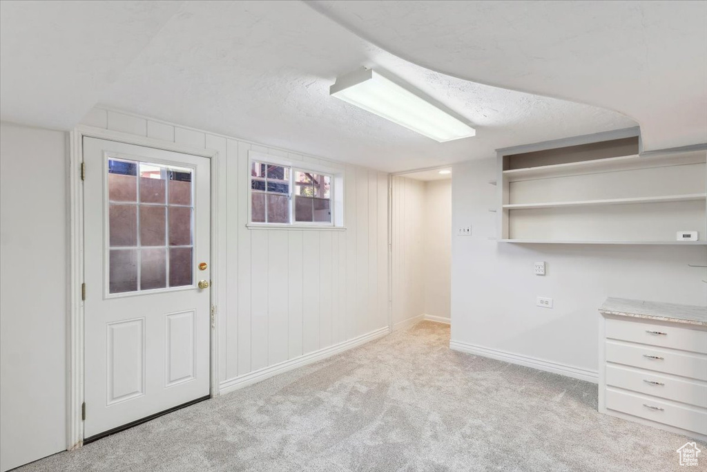 Basement featuring carpet floors, baseboards, and healthy amount of natural light