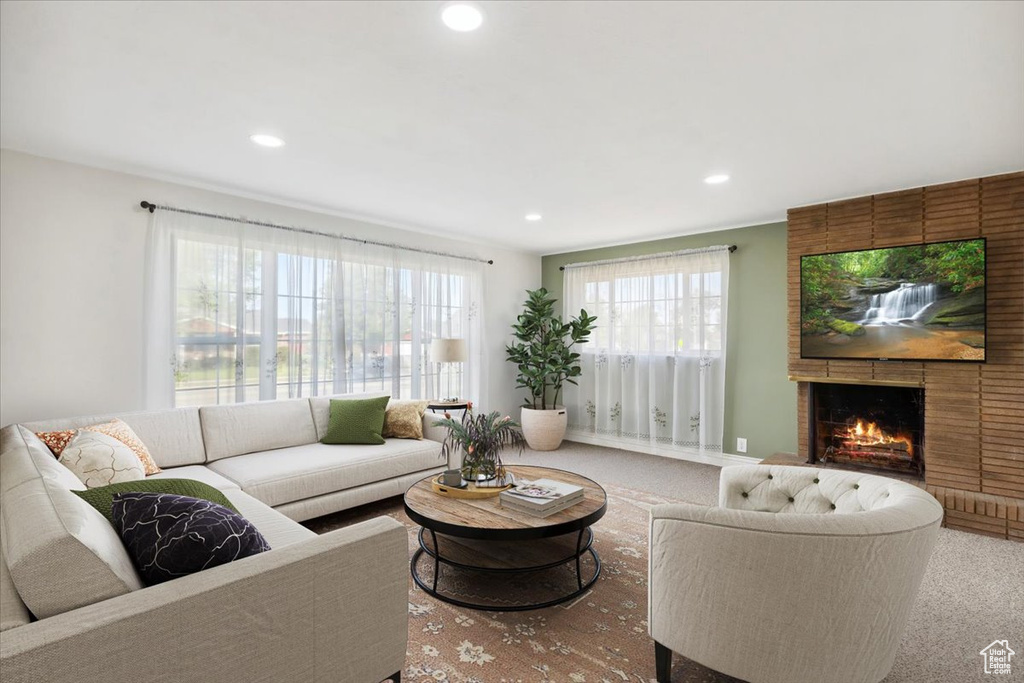 Living area featuring carpet, recessed lighting, and a fireplace