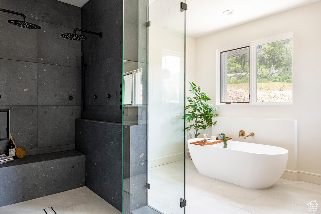 Full bath featuring tiled shower, baseboards, a freestanding bath, and tile patterned floors