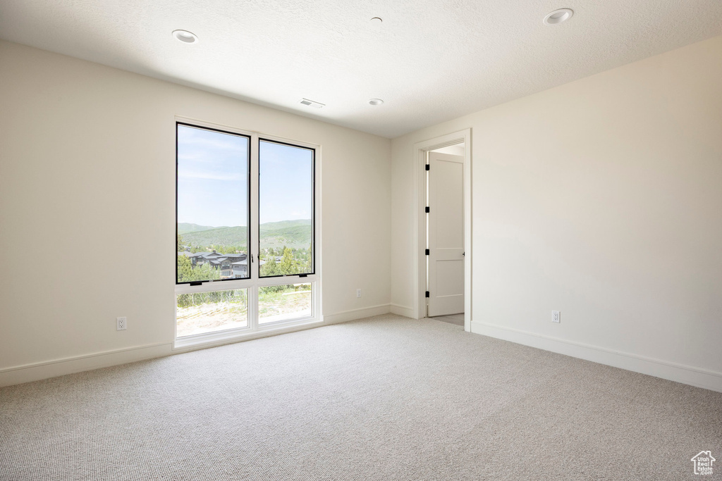 Unfurnished room featuring carpet, baseboards, and recessed lighting