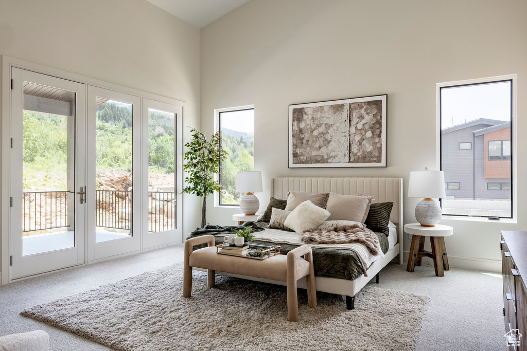 Carpeted bedroom featuring access to outside, a towering ceiling, and french doors