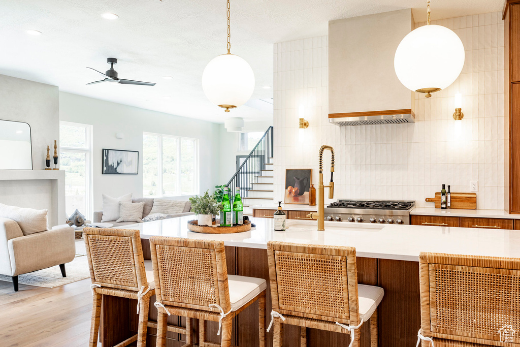 Kitchen with light countertops, decorative backsplash, open floor plan, hanging light fixtures, and recessed lighting