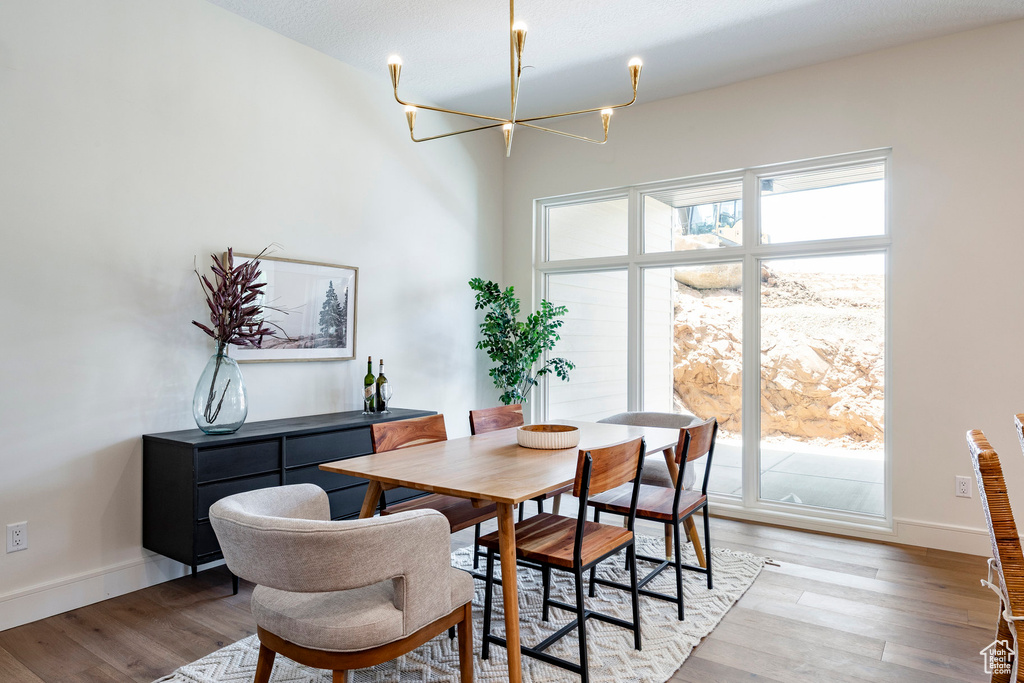 Dining room featuring a chandelier, baseboards, and light wood finished floors