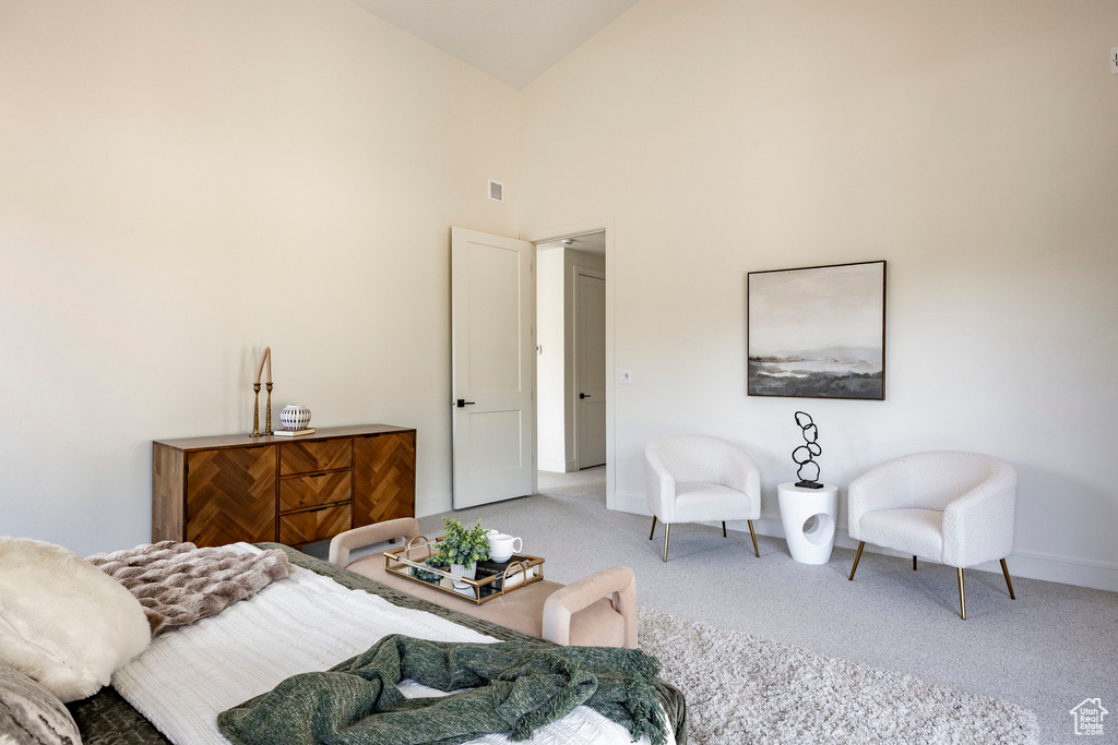 Carpeted bedroom featuring baseboards and high vaulted ceiling