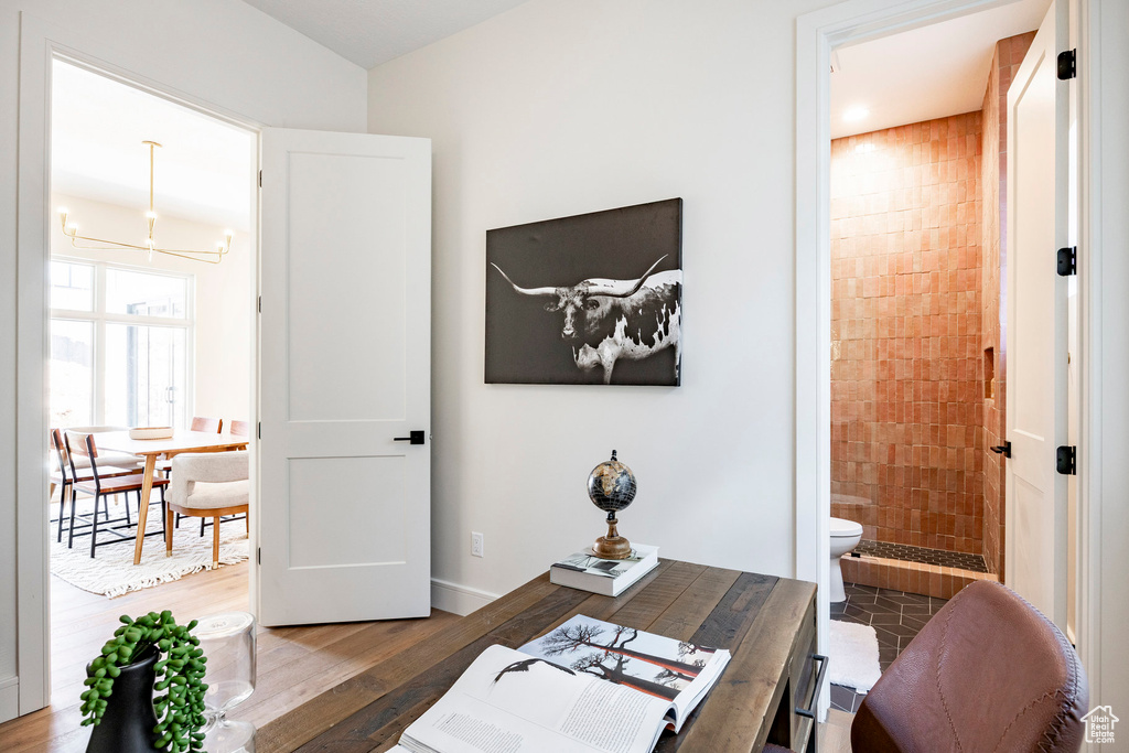 Home office with a chandelier, wood finished floors, and baseboards