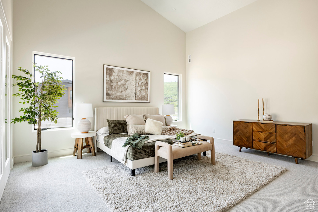 Bedroom with carpet, high vaulted ceiling, and baseboards