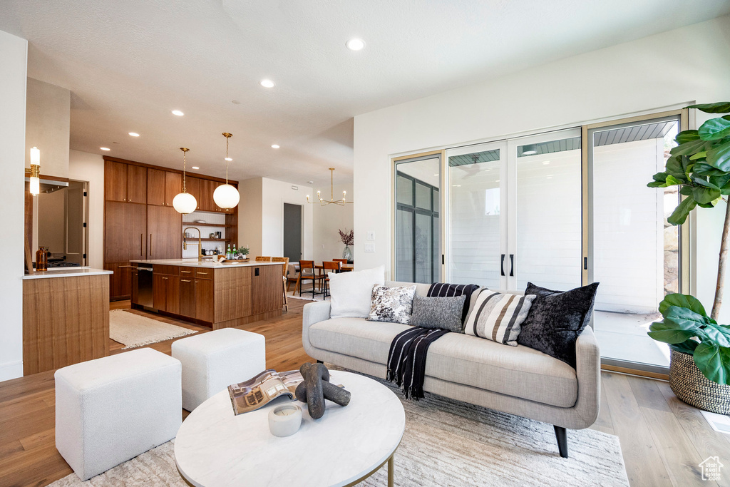 Living area featuring light wood-style flooring, recessed lighting, and a chandelier