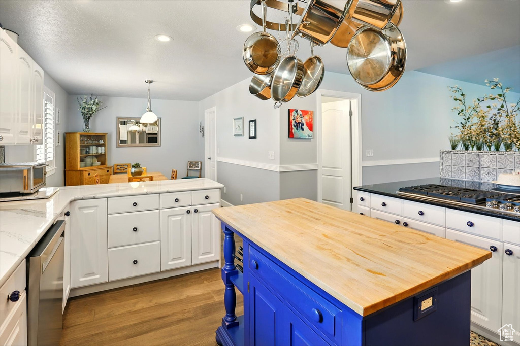 Kitchen with wooden counters, blue cabinetry, stainless steel appliances, light wood-style floors, and recessed lighting