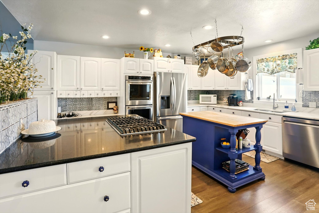 Kitchen with stainless steel appliances, a sink, tasteful backsplash, and recessed lighting