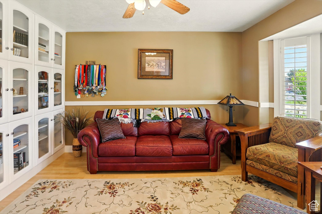 Living area with ceiling fan and wood finished floors