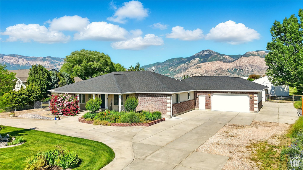 View of front of property featuring a mountain view, driveway, and an attached garage