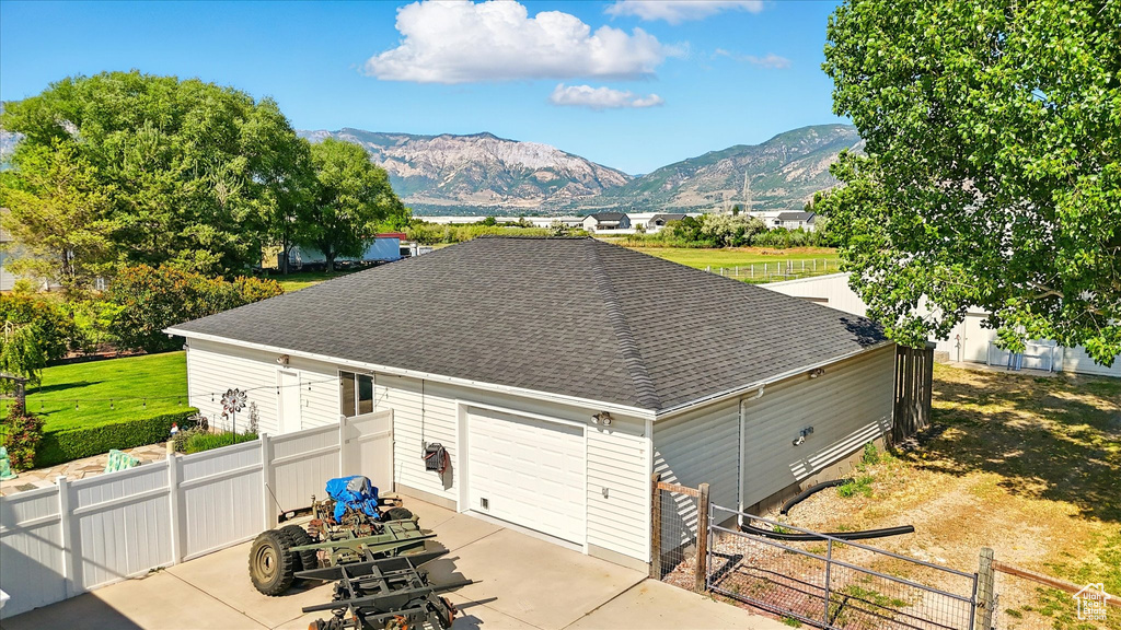 Garage with concrete driveway and a mountain view