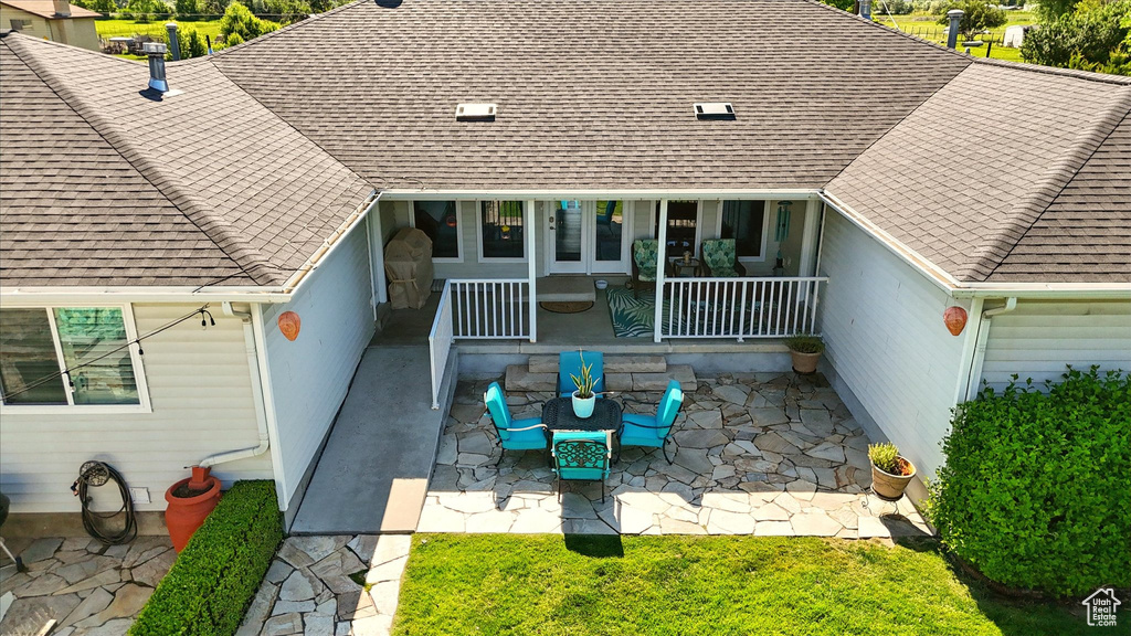 Back of property with a patio area and a shingled roof
