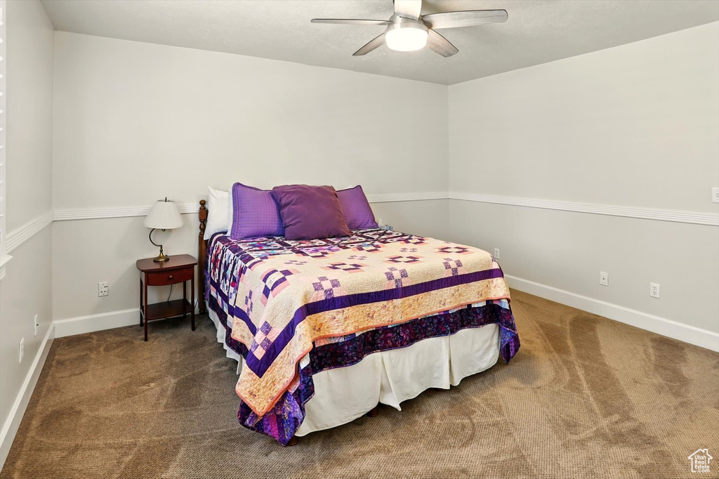 Carpeted bedroom featuring baseboards and ceiling fan