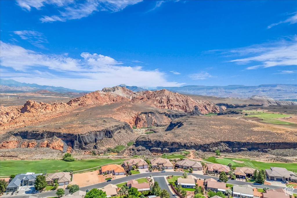 Aerial overview of property's location with a mountainous background and a golf course