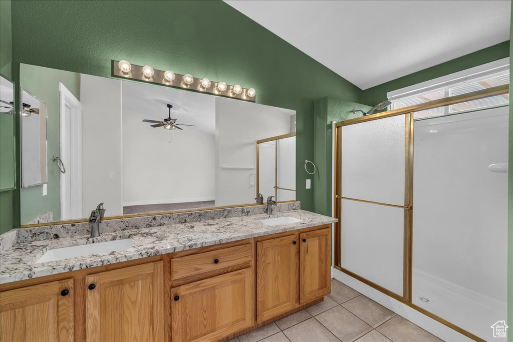 Bathroom with a shower stall, double vanity, tile patterned flooring, lofted ceiling, and a ceiling fan