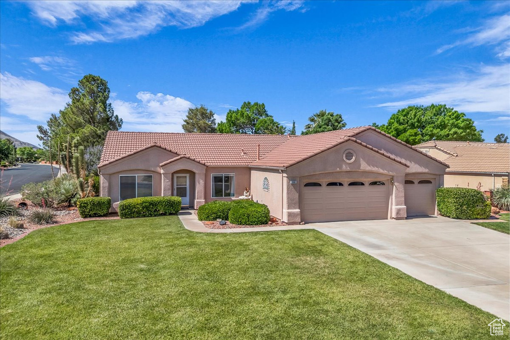View of front of home featuring a tile roof, a garage, stucco siding, and concrete driveway