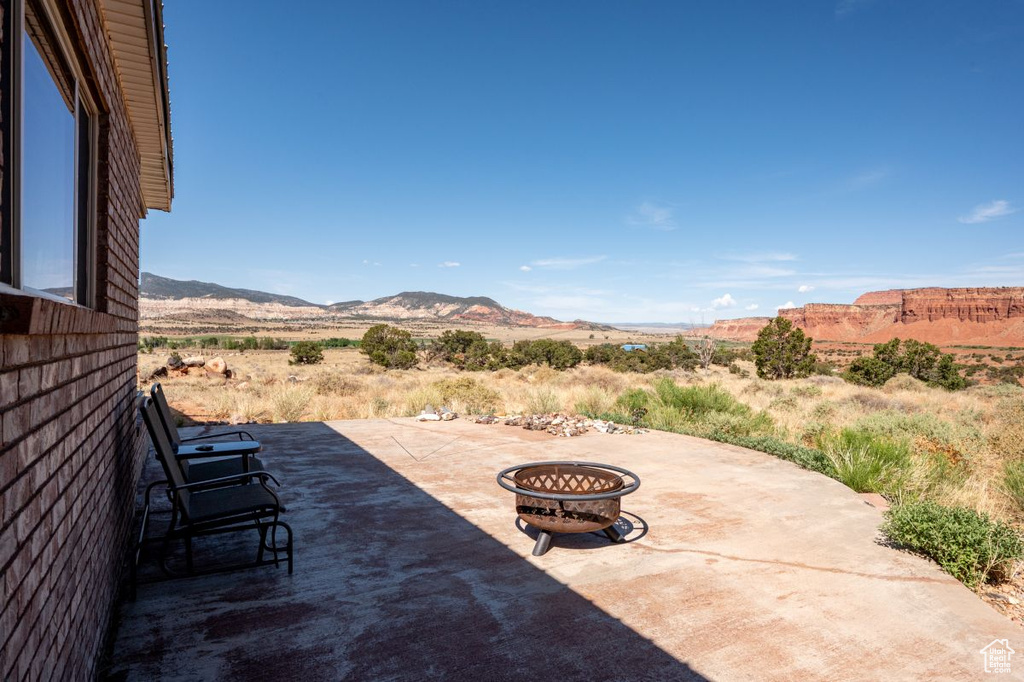 View of patio featuring an outdoor fire pit and a mountain view