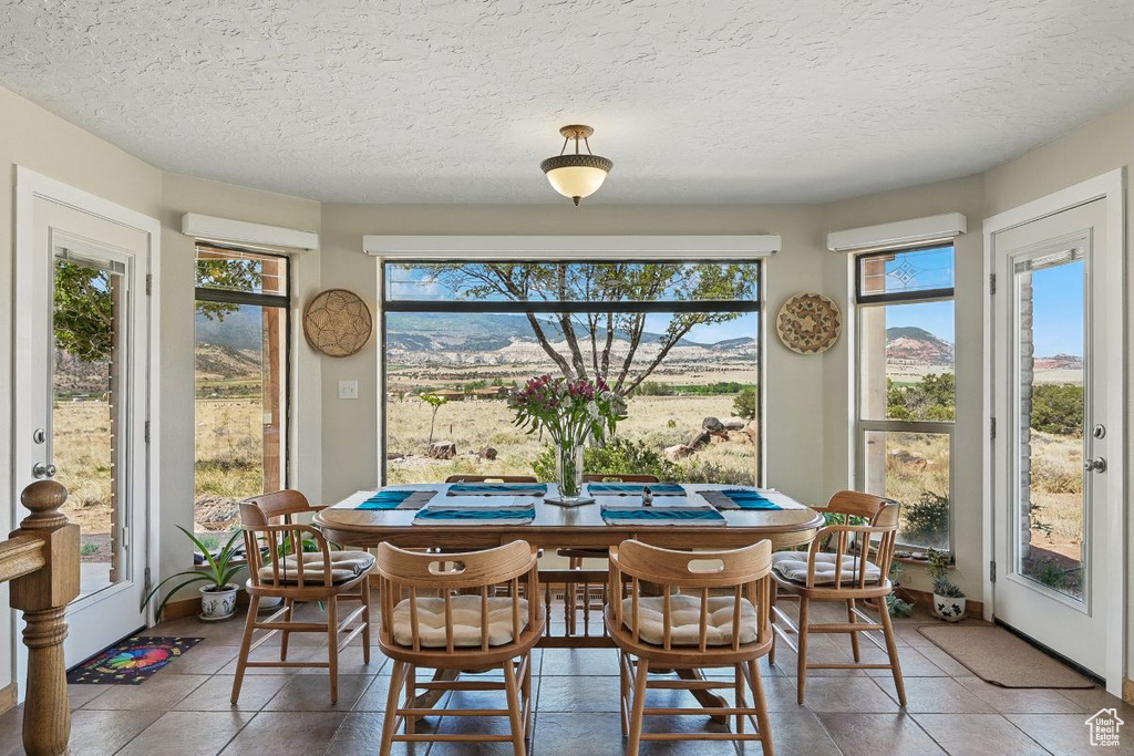 Dining space with tile patterned flooring and a textured ceiling