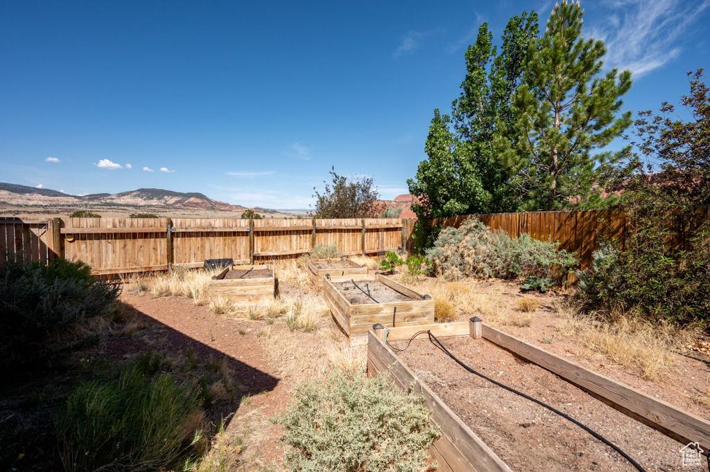 Fenced backyard featuring a garden and a mountain view