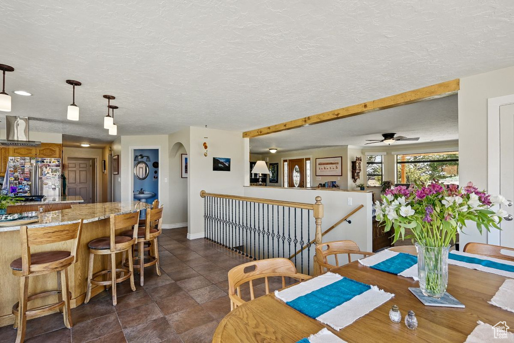 Dining area with baseboards, ceiling fan, and a textured ceiling